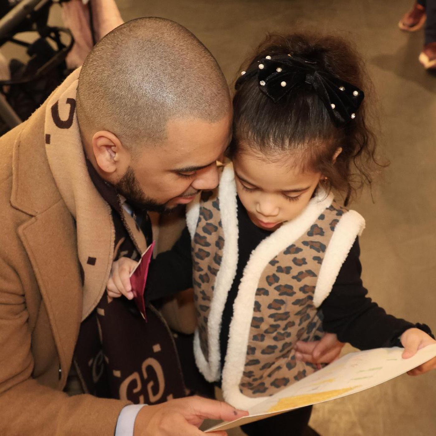 An adult and child looking at student art together